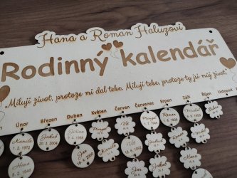 Dřevěný rodinný kalendář se štítky se jmény a daty pod názvy měsíců